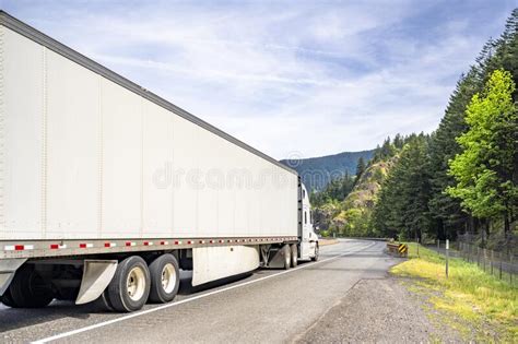 White Big Rig Long Haul Industrial Semi Truck Transporting Goods In Dry