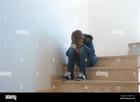 Sad Boy Sitting Alone In The Corner In The Staircase Stock Photo Alamy