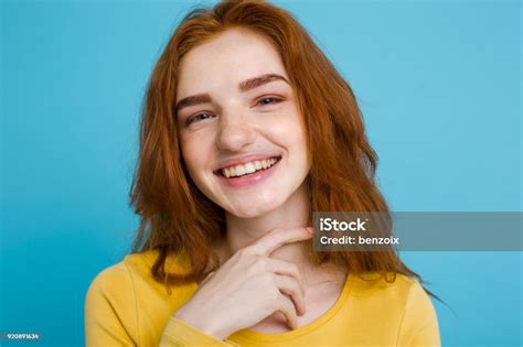 headshot portrait of happy ginger red hair girl with freckles smiling looking at camera pastel