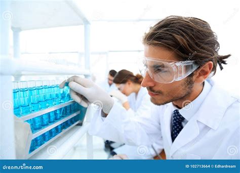 Laboratory Assistant In Goggles And A Lab Coat With A Test Tube Stock