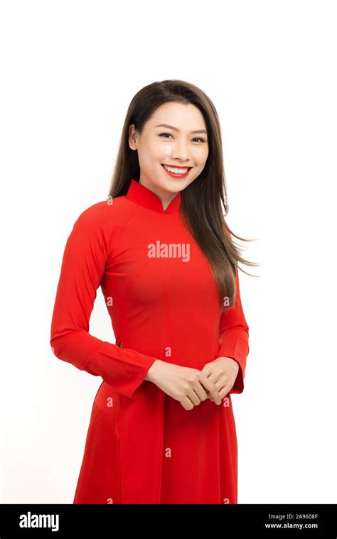 close up portrait of beautiful asian girl dressed in traditional ao dai red dress stands over