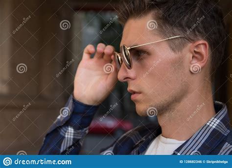 Close Up Of A Man Who Takes Off His Sunglasses Male Portrait In Profile Where He Holds Glasses