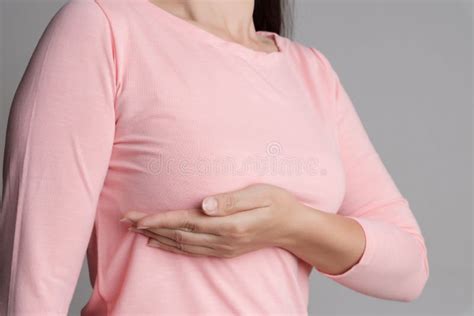 Woman Hand Checking Lumps On Her Breast For Signs Of Breast Cancer On