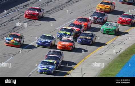 Nascar Driver Jeff Gordon Leads A Pack Of Cars Through Turn 4 During