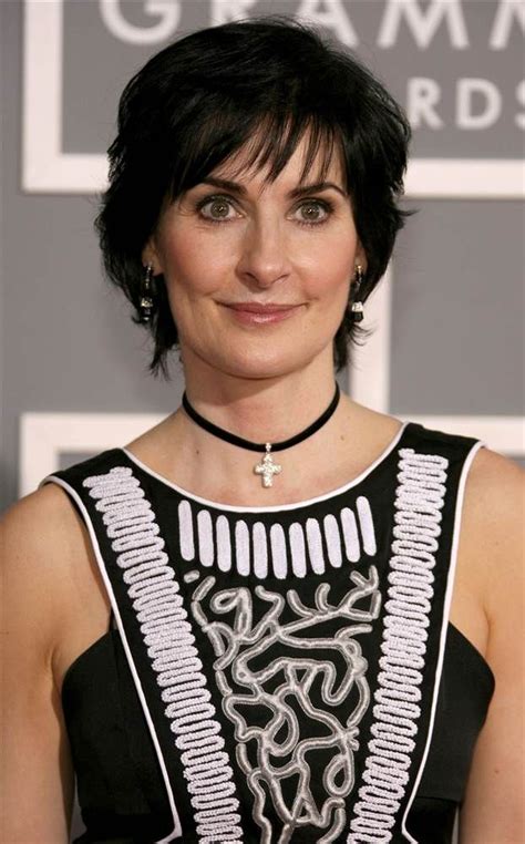 A Woman With Short Black Hair Wearing A Black And White Dress At An