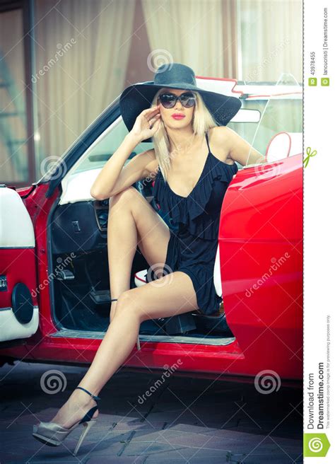 de zomerportret van modieus blonde uitstekende vrouw met lange benen die dichtbij rode retro