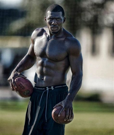 A Man With No Shirt Holding A Football