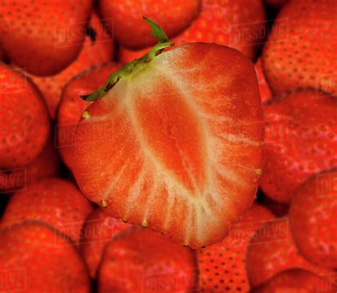 Half A Strawberry On Whole Strawberries Stock Photo Dissolve