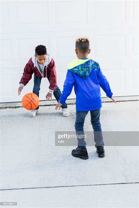 Two Boys Playing Basketball On Driveway High Res Stock Photo Getty Images