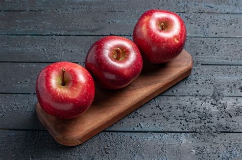 Frente maçãs vermelhas frescas frutas maduras maduras na mesa azul escuro planta frutas cor