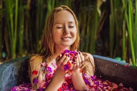 Mujer Joven Atractiva En El Baño Con Pétalos De Flores Tropicales Y