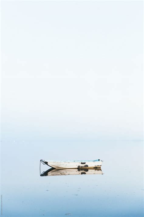 Boat Sitting In Still Water Relecting By Stocksy Contributor Laura
