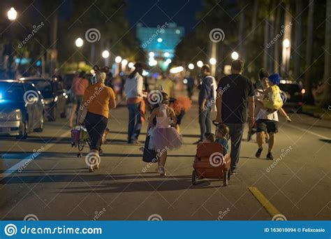 People Walking Down The Streets Trick Or Treating On Halloween Night