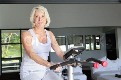 Mature Woman Using An Exercise Bike At Stock Image Colourbox