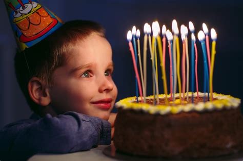Premium Photo Birthday A Little Boy Blows Out Candles On The Stoke
