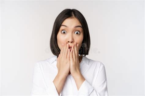 Close Up Face Of Asian Woman Gasping Looking Shocked And Speechless Holding Hands Near Mouth