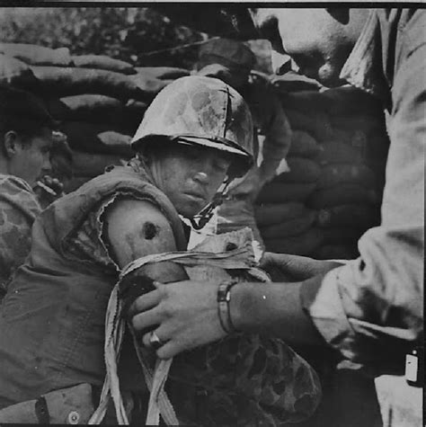 An Old Black And White Photo Of A Soldier Holding Another Soldiers
