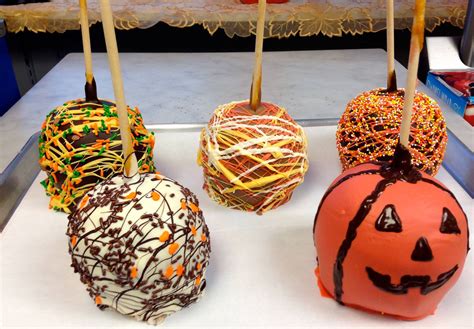 Four Pumpkin Shaped Cake Pops With Sprinkles On Them