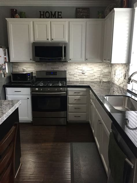 Beautiful kitchen with creamy white shaker cabinets paired with brown granite countertops and white porcelain diamond pattern tile backsplash. BLACK GRANITE COUNTERTOPS - DISCOUNT PRICES - New View