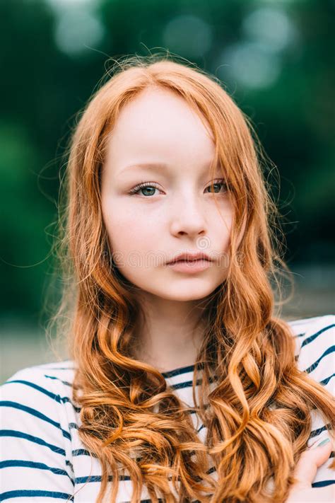 A Beautiful Girl With Green Eyes And Long Curly Red Hair