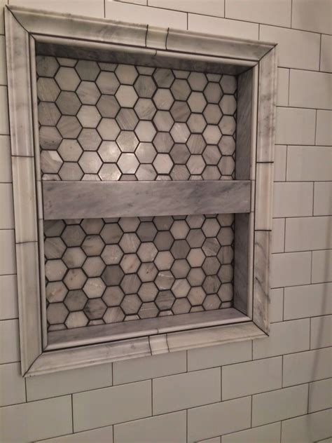 Clean the grout lines 20 to 30 minutes after filling or when the joints begin to harden and dry. Shower shelf with marble hex tile and dark grout (With ...