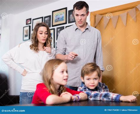 Father And Mother Correcting Their Children Stock Photo Image Of
