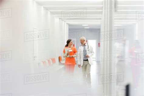 Doctor And Nurse Making Rounds In Hospital Corridor Stock Photo