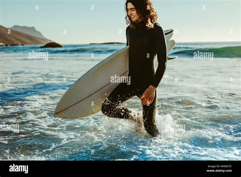 Young Surfer Coming Out Of The Water On The Beach Hi Res Stock