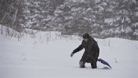 An Unidentified Woman Walks With A Shovel Through Knee Deep Snow In A