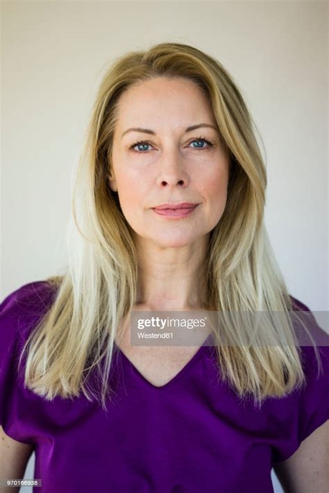 Portrait Of Blond Mature Woman Wearing Purple Top High Res