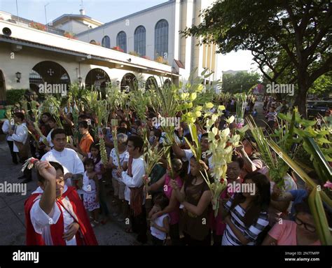 A Filipino Catholic Priest Blesses Palm Fronds Outside The Santo