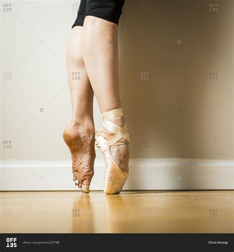 Side View Of Ballerina Wearing One Pointe Shoe Standing On Tip Toes
