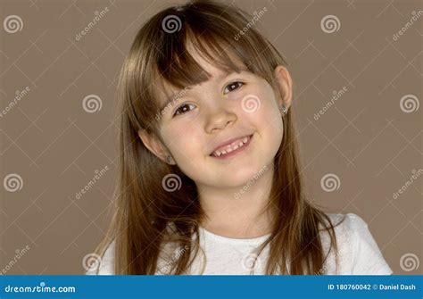 Portrait Of A Little Cute 7 Year Old Girl In A White Tshirt Posing And