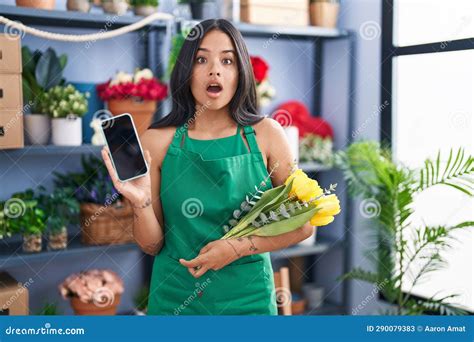 Brunette Woman Working At Florist Shop Holding Smartphone Afraid And