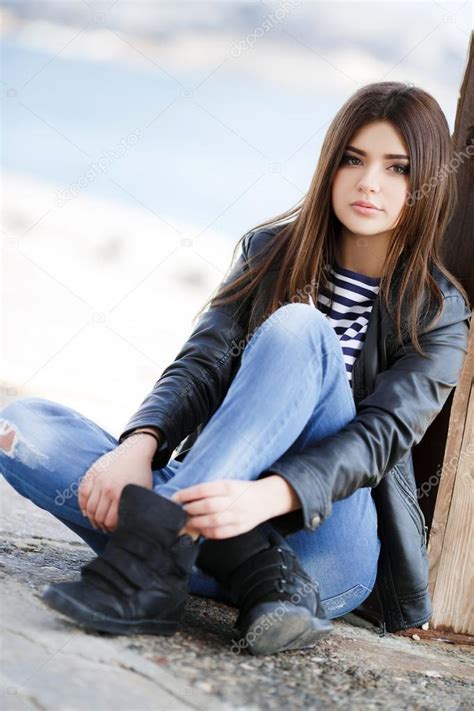 Portrait Of A Beautiful Young Woman Sitting On The Sidewalk Stock