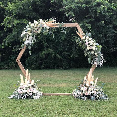 Neutral Flowers And Greenery Installation On Hexagon Wedding Ceremony Arch Perfect For A Garden