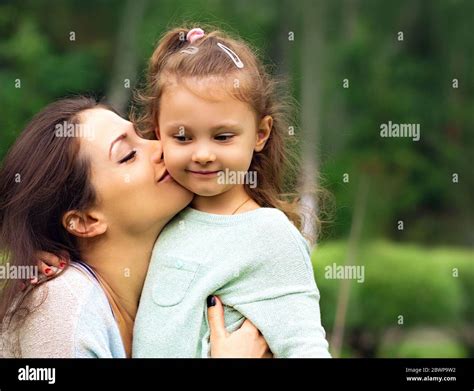 Beautiful Mother Hugging And Kissing Her Cute Small Daughter On Summer