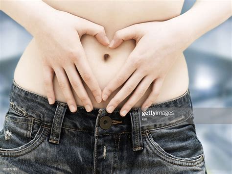 Girl Teenager In Jeans Bare Belly With Fingers Forming A Heart Shape