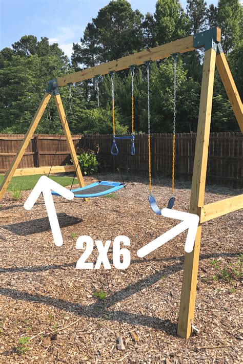 A Wooden Swing Set With Two Swings In The Middle And An Arrow Pointing