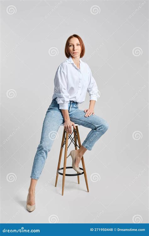 Portrait Of Middle Aged Caucasian Redhead Woman In White Shirt And Blue