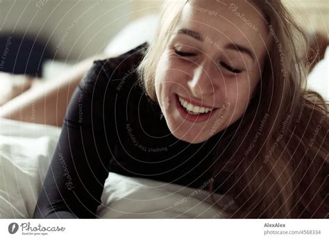 Portrait Of Young Blonde Smiling Woman Lying In Bed A Royalty Free