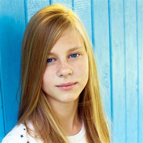 Portrait Of Pretty Teen Girl On Blue Wooden Wall Background Stock Photo