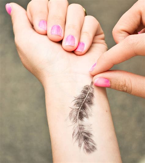 Photo Tatouage femme une plume détaillée sur le poignet