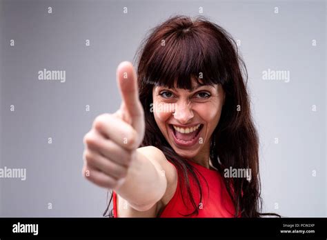 Happy Enthusiastic Attractive Dark Haired Woman Giving A Thumbs Up