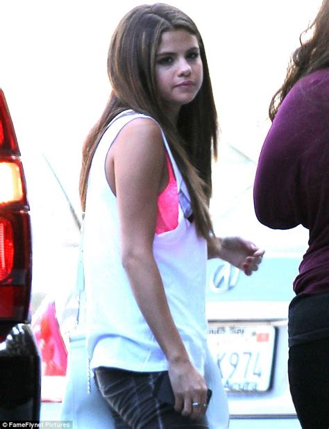 Selena Gomez Flashes Her Hot Pink Bra As She Wears A White Vest Top To