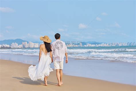 年轻情侣牵手海边散步背影高清图片下载 正版图片501740386 摄图网