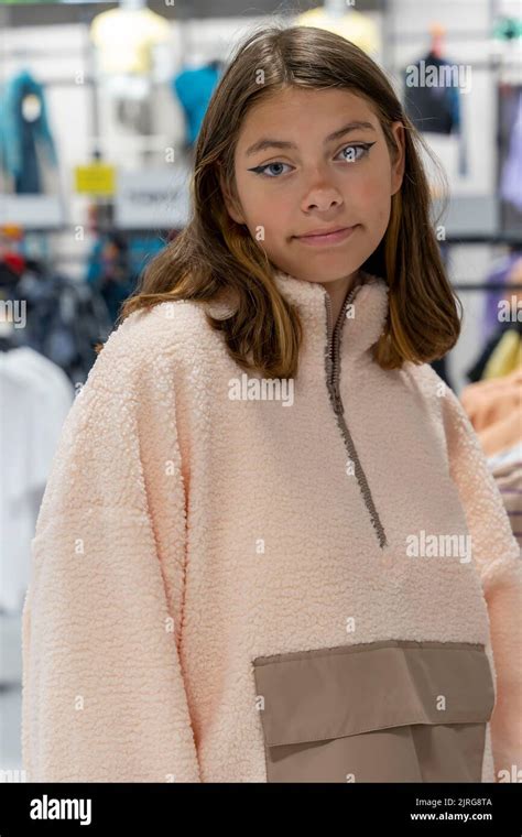 Beautiful Girl In A Clothing Store Tries On A Fashionable Sweatshirt
