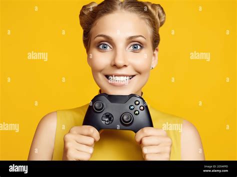 Portrait Of Gorgeous Happy Blonde Gamer Girl Playing Video Games Using Joystick On Yellow