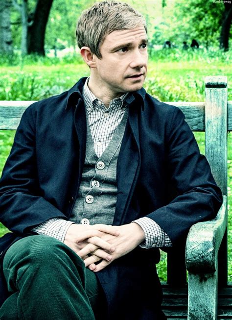 a man sitting on top of a wooden bench