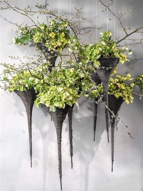 Three Metal Vases With Plants Hanging From Them